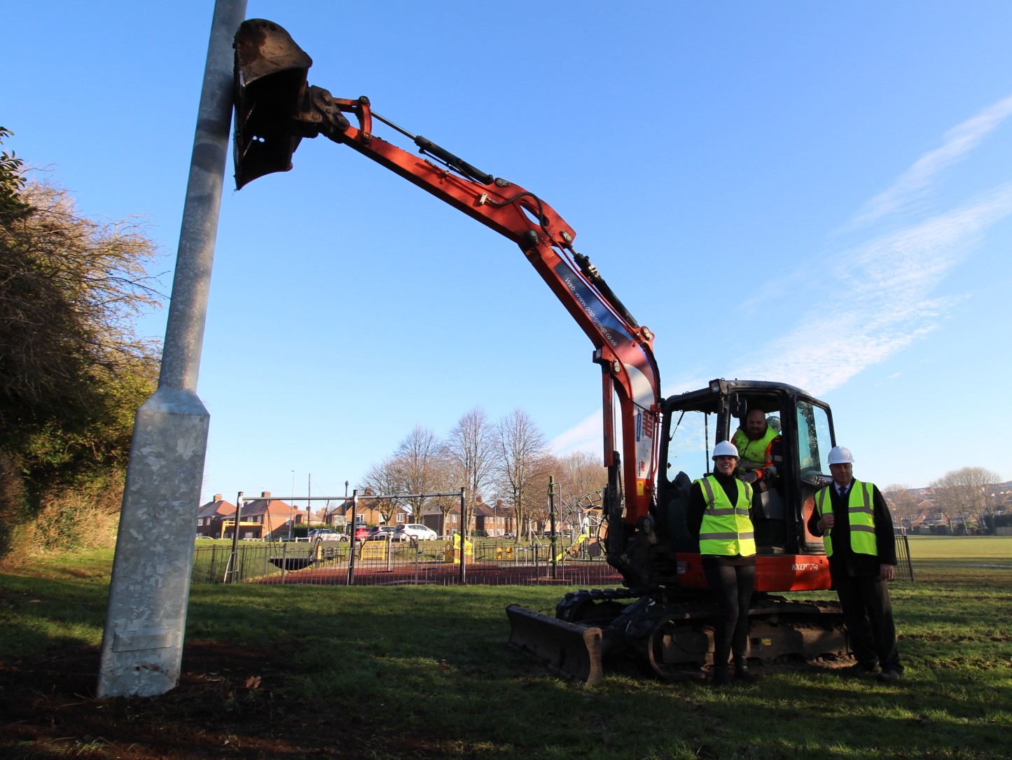 Gedling Borough Council Public Protection Officer with Portfolio Holder for Public Protection, Councillor David Ellis and contractors, next to the new CCTV tower at Killisick Recreation Ground. To the left the new CCTV tower can be seen and the park/play area is in the background. In the centre of the photo is a 